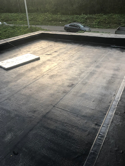 Worker applying balcony coating with roller